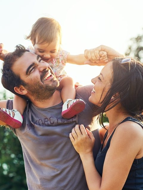 Family,,dad,and,daughter,on,shoulders,in,park,with,mom,